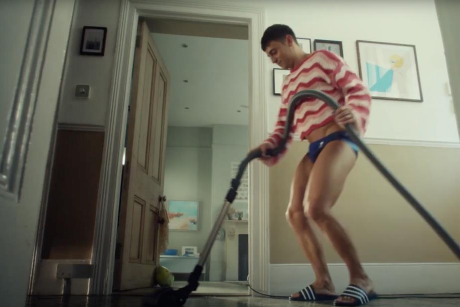 Tom Daley vacuums his hall, dressed in trunks and a cropped jumper