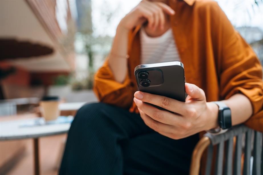 Stock photo of someone holding a smartphone (©GettyImages)