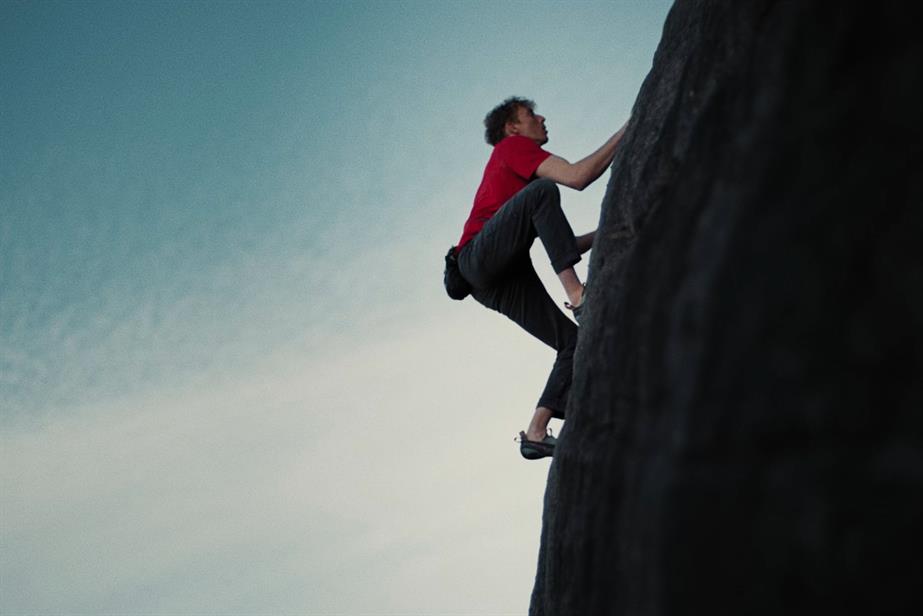 A man free climbs a vertical rock face