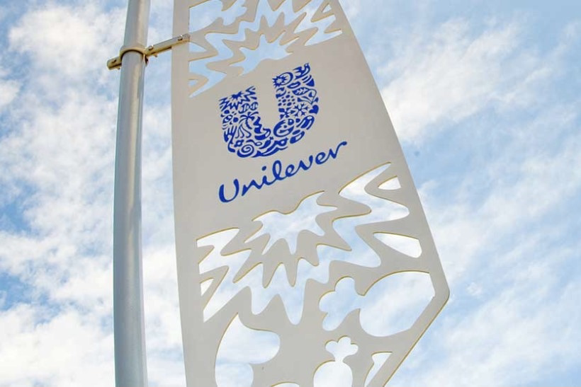 Unilever's logo displayed on a flag flying against a cloudy and blue sky