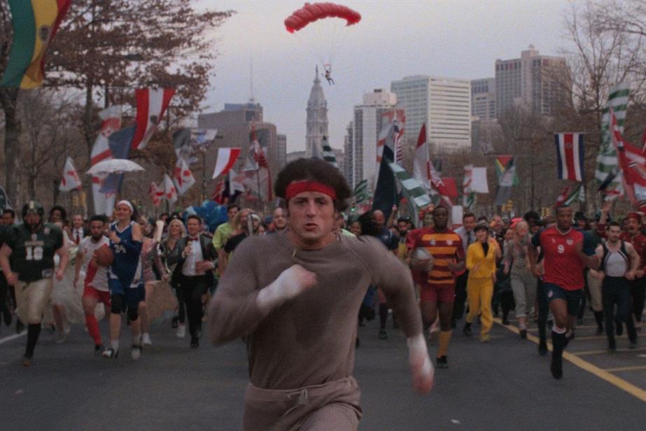 Rocky running in the street with crowd of athletes running behind him