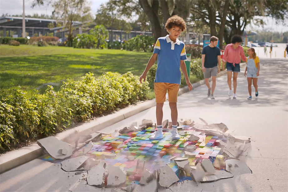 A boy about to enter Legoland Parks feels lego bricks beneath him