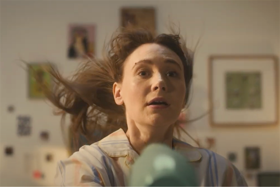 a woman blowing her hair with a hairdryer