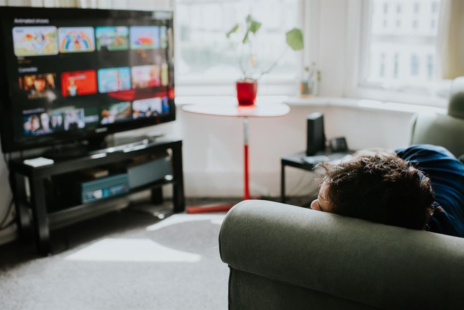 A man watches TV from his sofa