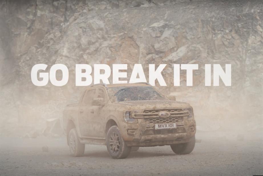 A still from a Ford ad depicting a dirt-covered Ranger pickup, with copy reading 'Go break it in'