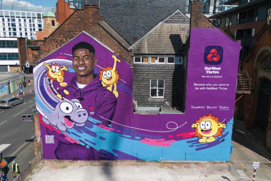 A mural on the side of a house for NatWest with a man in a NatWest hoodie and cartoon characters swooshing around him