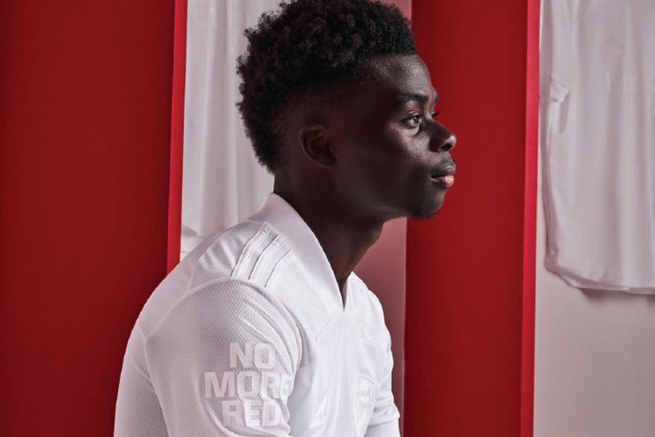 Bukayo Saka in a white shirt looking to the right of the screen with 'no more red' written on the shirt