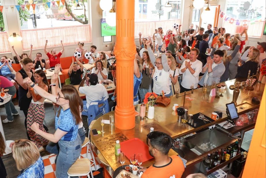 Football fans celebrating in The Queen's Header pub