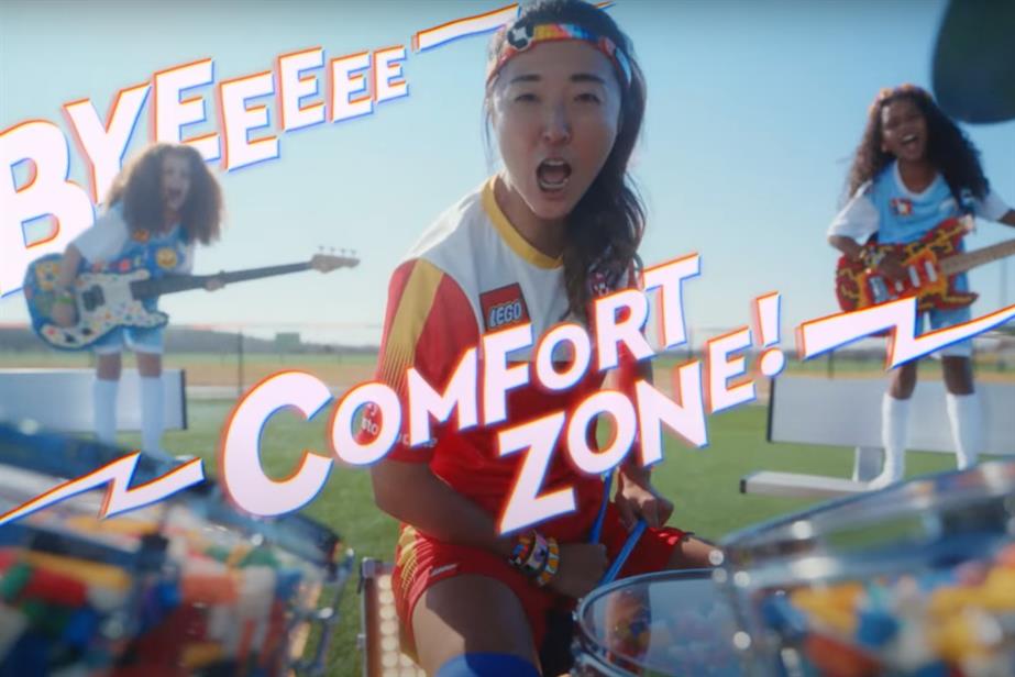 Footballer playing the drums on a football pitch with copy saying bye comfort zone