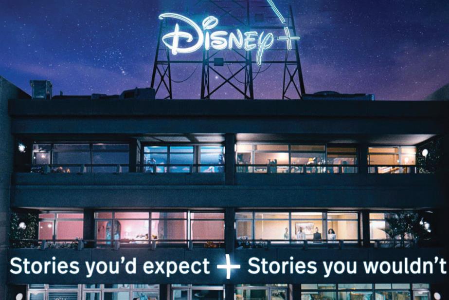 Offices at night with the Disney + logo lit up on top and a sign saying 'Stories you'd expect + stories you wouldn't'
