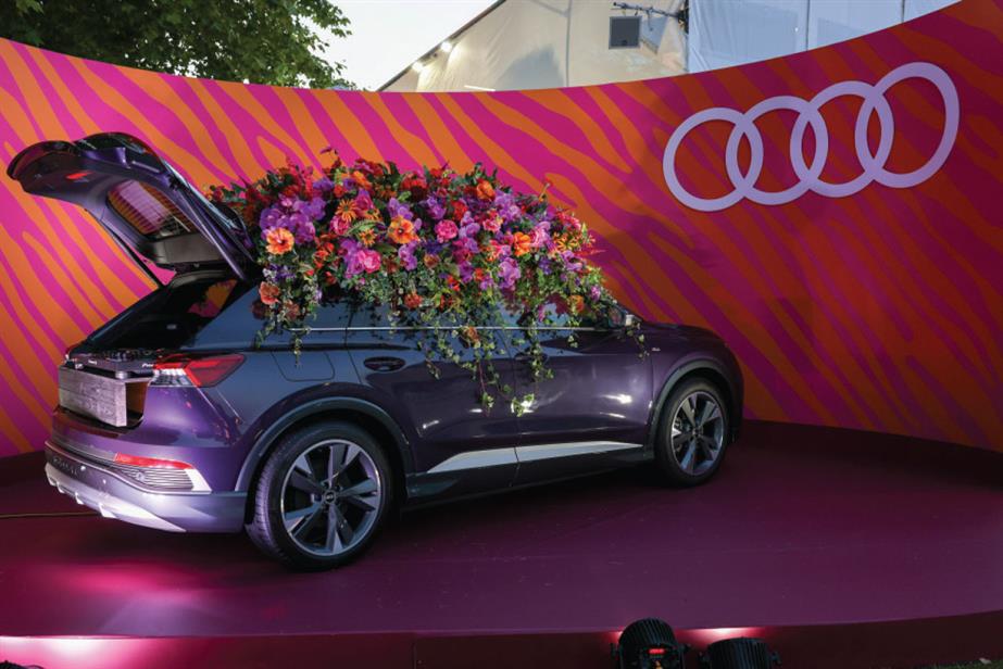 A car with the boot open and lots of flowers on the top