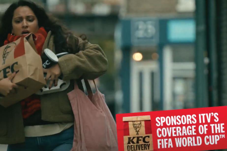 A woman struggling down a street with bags of KFC and the text 'Sponsors ITV's coverage of the Fifa World Cup'