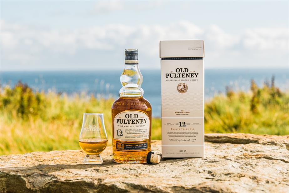 Bottle and glass of Old Pulteney on a beach