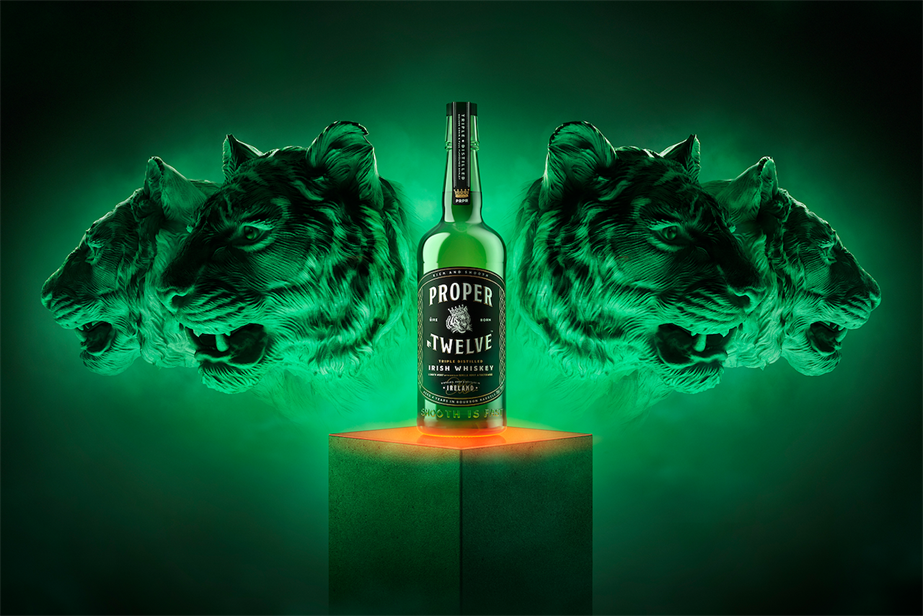 Promotional graphic for Proper No. Twelve Whiskey, showing a dark green background, tiger heads and a bottle of the whiskey in the centre