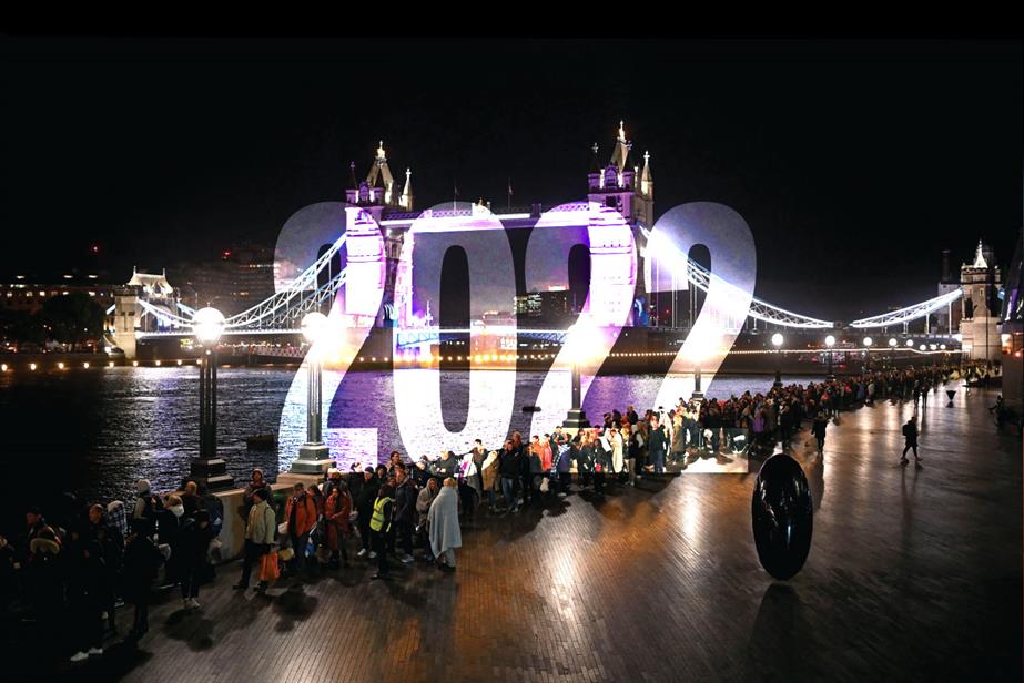 Image of people queuing by the Thames to see the Queen's coffin at night with '2022' superimposed