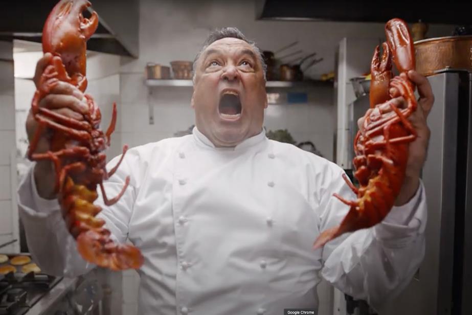 a chef screams in horror while holding two massive cooked lobsters in each hand