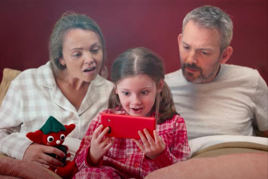 Family in bed looking at phone screen together