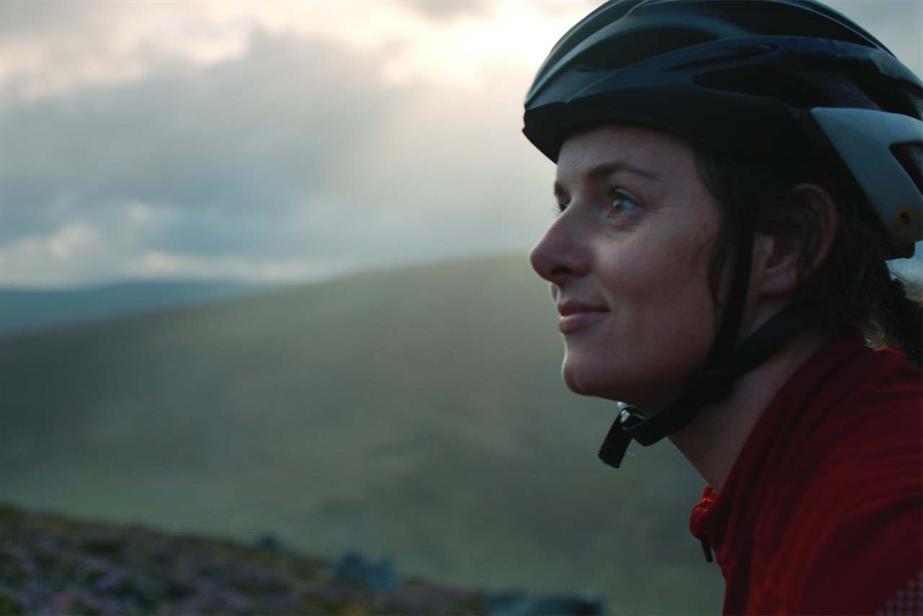 Woman in a bike helmet in irish countryside