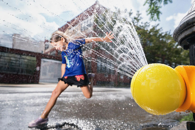 Child playing in fire hydrant spray