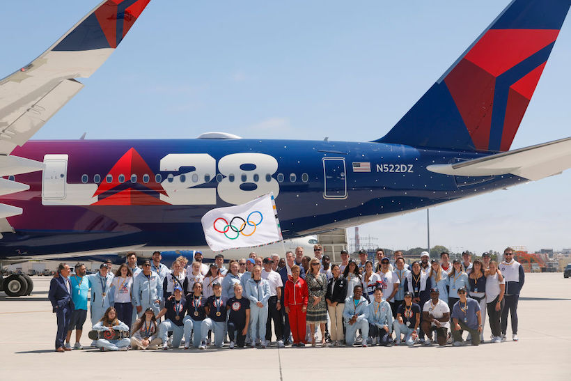 The Los Angeles 2028 Olympics team poses with Los Angeles Mayor Karen Bass outside a branded plane