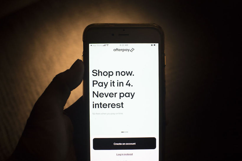 Hand holding smart phone displaying Afterpay app