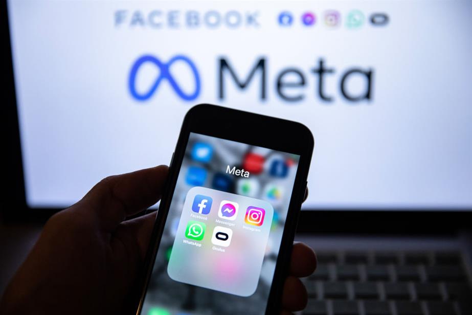 App icons of Facebook, Messenger, Instagram, WhatsApp, and Oculus VR are displayed on a smartphone screen with a Meta logo in the background.