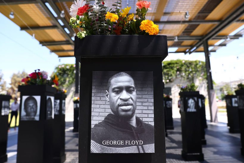 A photograph of George Floyd (C) is displayed along with other photographs at the Say Their Names memorial exhibit at Martin Luther King Jr. Promenade on July 20, 2021 in San Diego, California