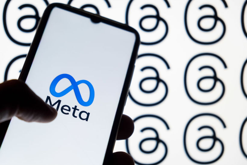 Hand holding smart phone displaying Meta logo