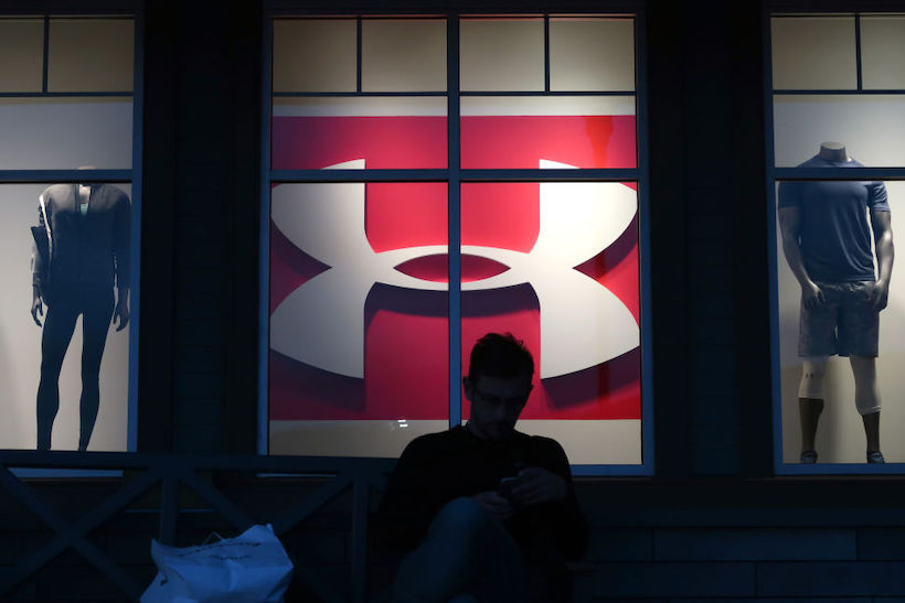 Person sitting outside Under Armour retail store