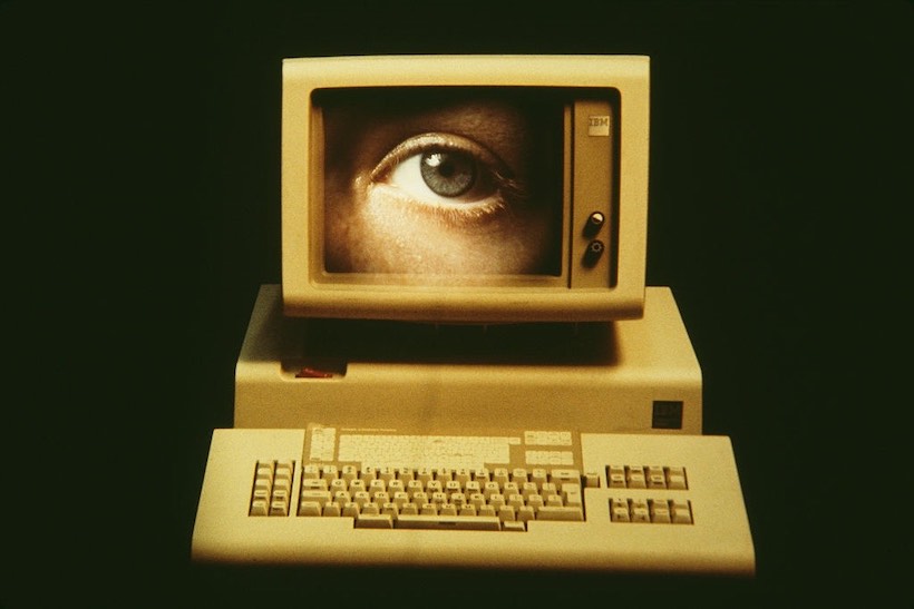 Old computer monitor displaying painting of an eye