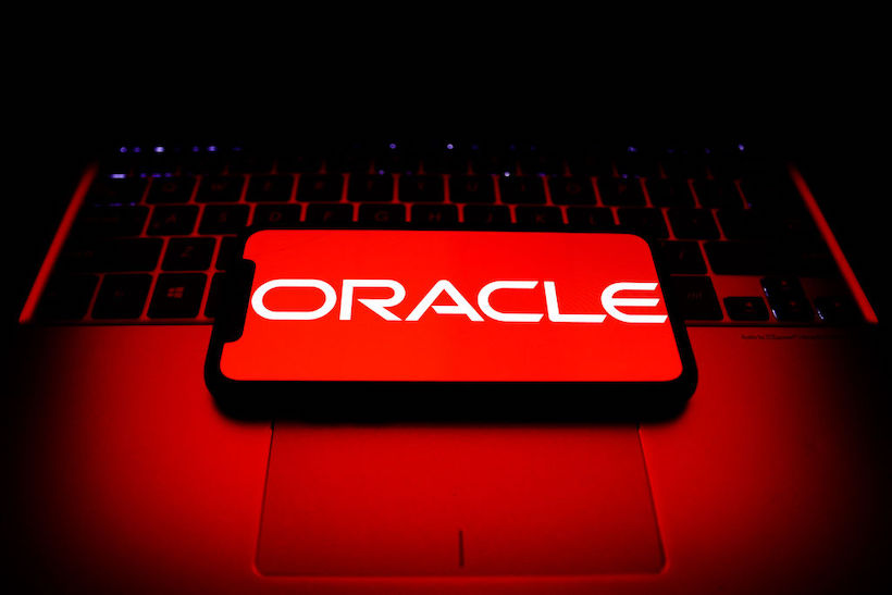 Oracle logo displayed on a phone screen and a laptop keyboard