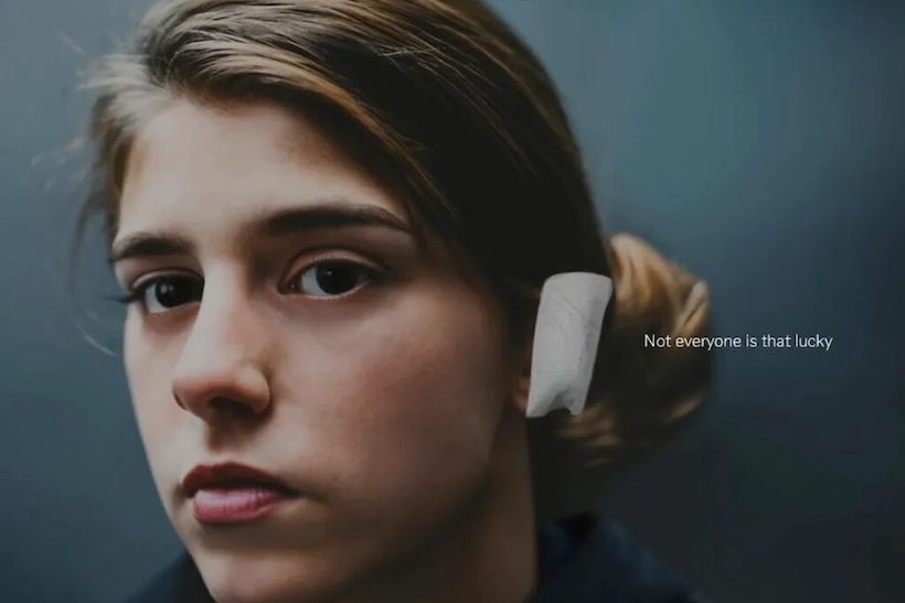 Young woman with bandage on ear