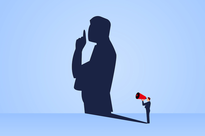 Clip art of a businessman holding a megaphone, casting a shadow with finger over mouth in shushing gesture