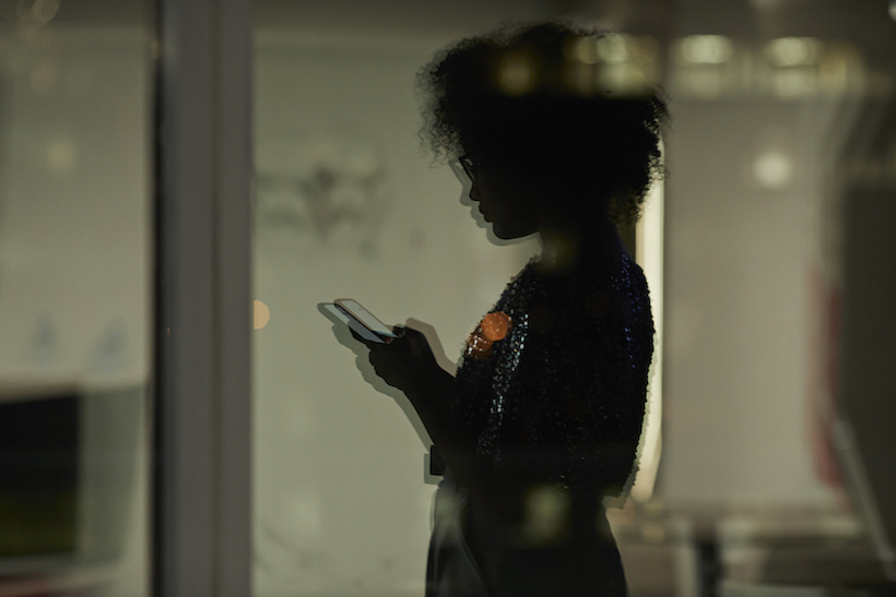 Silhouette of woman holding smart phone