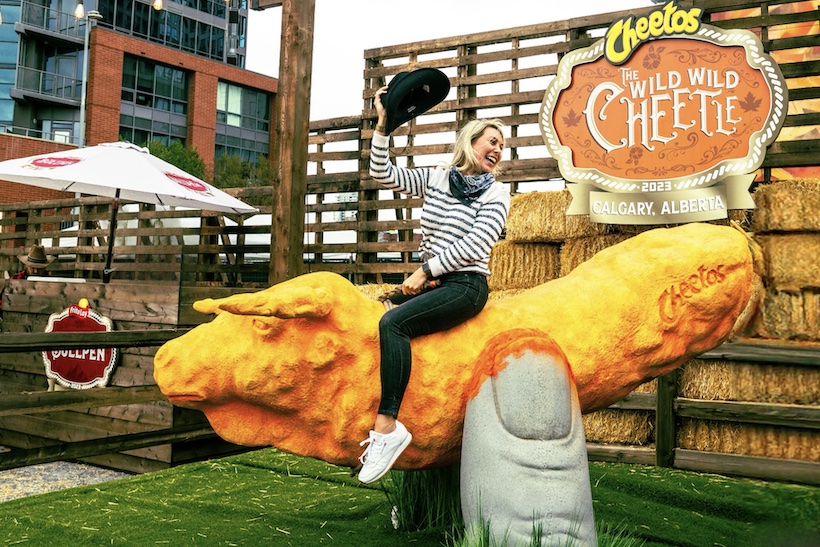 Woman riding on giant Cheetos ride