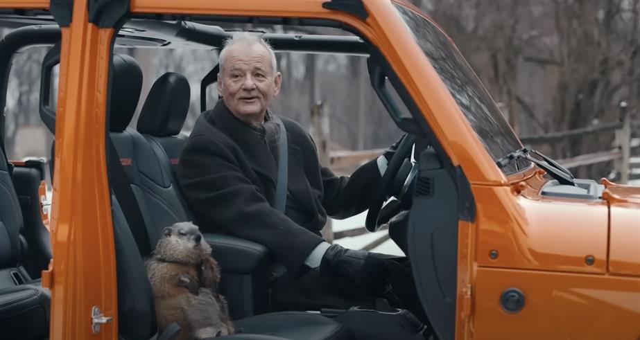 Bill Murray sitting in a Jeep with a groundhog
