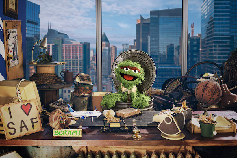Oscar the Grouch in corporate office with junk on his desk
