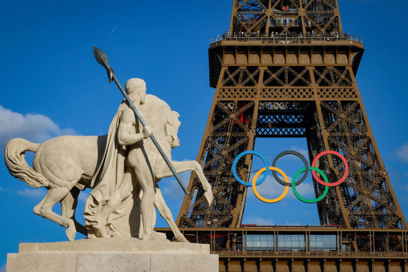 The Olympic rings on the Eiffel Tower near the restored statue of Cavalier Arabe in Paris.