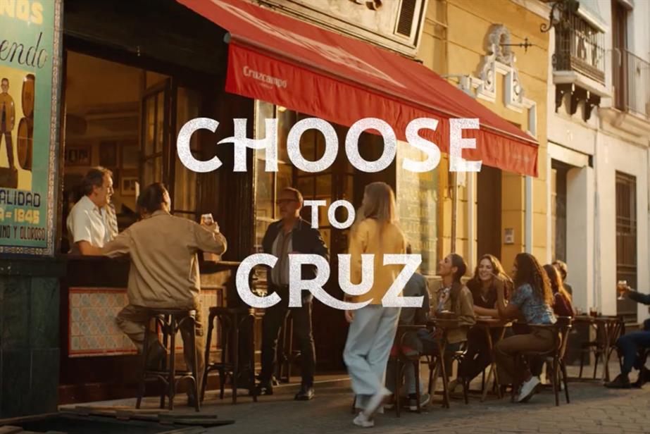 An ad still showing a man drinking Cruzcampo under the awning of a Seville bar