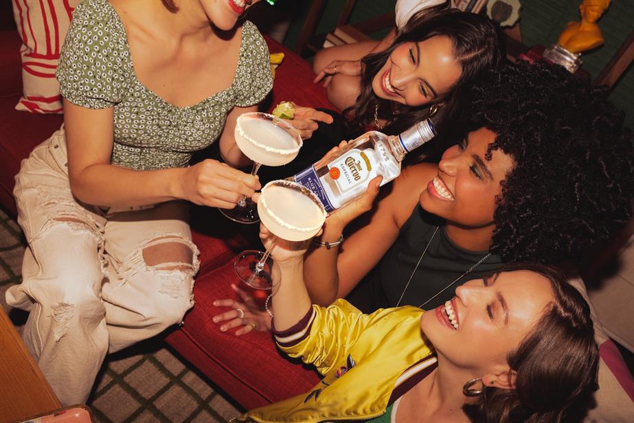 revellers holding a bottle of tequila