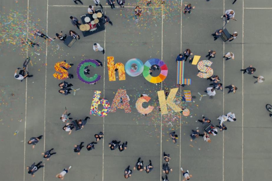 Kids in playground holding letters that spell out School's back