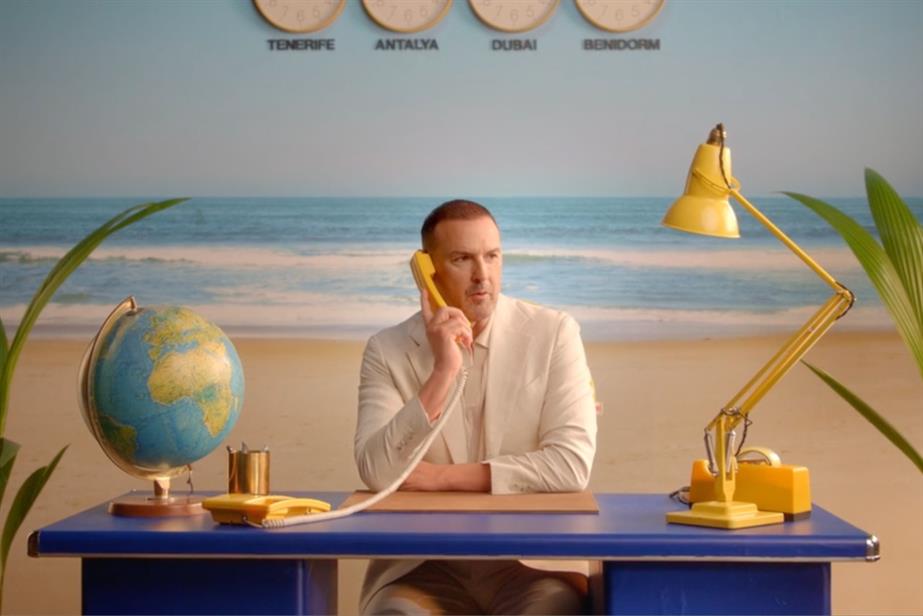 Paddy McGuinness behind a desk on the phone