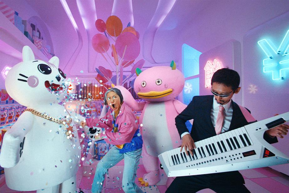 A middle-aged woman, Tina, punches a giant Japanese cat mascot in the chest in an ad for Wise 