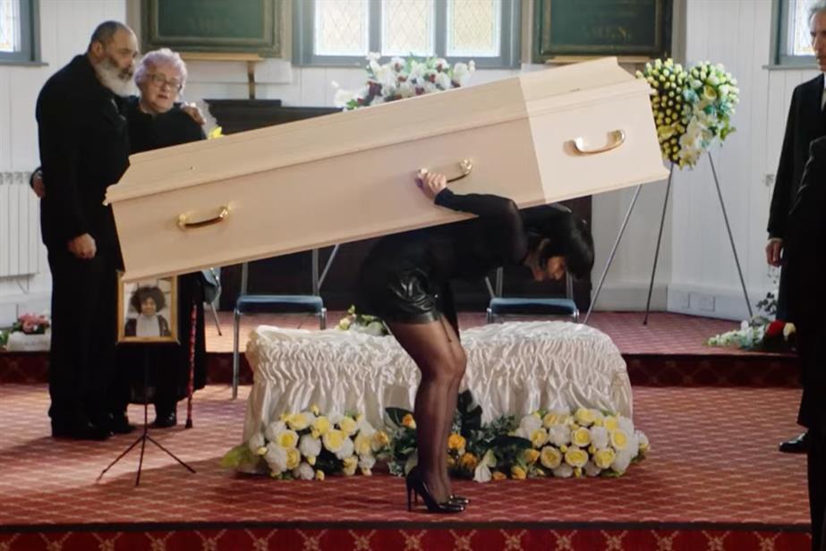 Woman carrying a coffin on her back