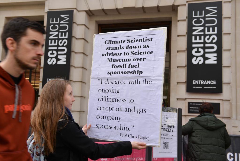 A protester holds a placard during a protest against sponsorship of the Science Museum by fossil fuels corporations Shell and Adani. Photo: Thomas Krych via Getty Images)
