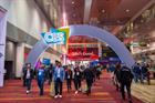 People walking by CES signage