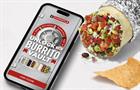 Burrito next to smartphone displaying Chipotle Burrito Vault ad