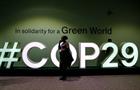 Attendees at COP29 walk by event signage