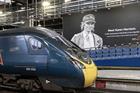 An Avanti train pulling into London Euston with a billboard showing a picture of Karen Harrison