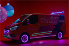 A red van with 'Chri23rdmas' on the side and neon lights